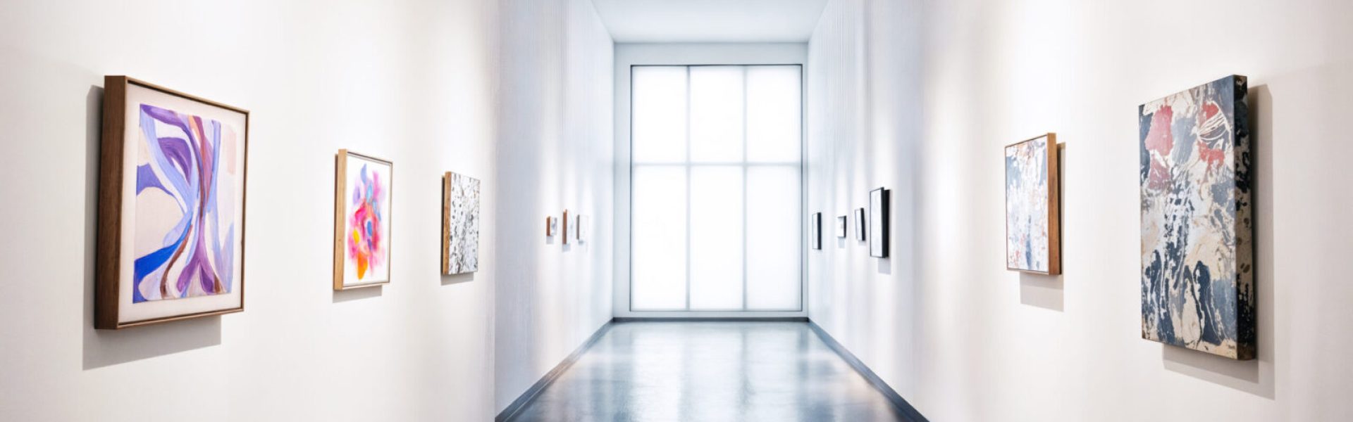 korytarz galerii sztuki z wystawionymi obrazami